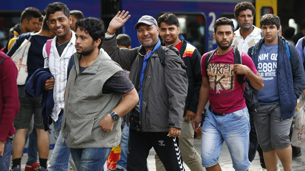 Migrants arrive at the main station in Munich, Germany September 5, 2015. Austria and Germany threw open their borders to thousands of exhausted migrants on Saturday, bussed to the Hungarian border by a right-wing government that had tried to stop them but was overwhelmed by the sheer numbers reaching Europe's frontiers.Left to walk the last yards into Austria, rain-soaked migrants, many of them refugees from Syria's civil war, were whisked by train and shuttle bus to Vienna, where many said they were resolved to continue on to Germany.             REUTERS/Michael Dalder  - RTX1R840