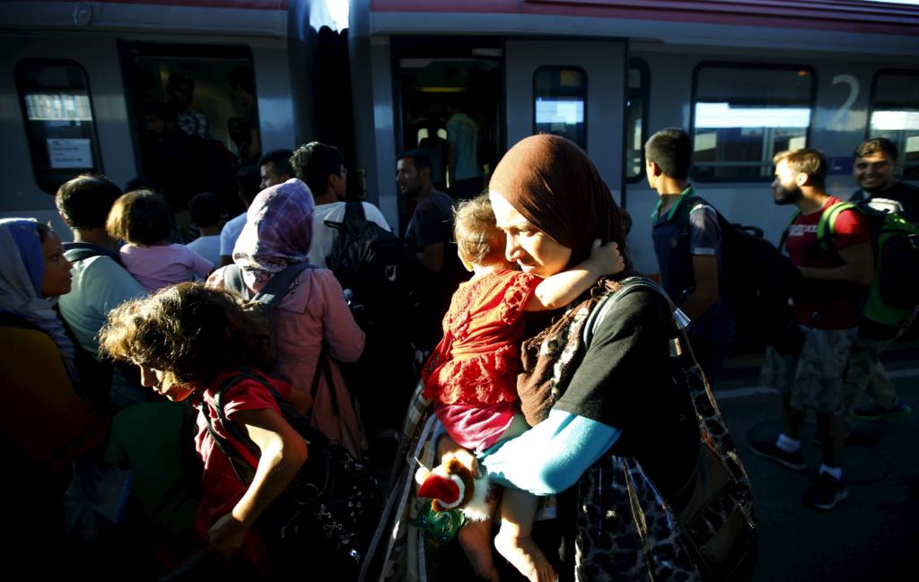 Travellers believed to be migrants coming from Hungary enter a train to Germany at the railway station in Vienna, Austria, August 31, 2015. Austrian authorities toughened controls along the country's eastern borders on Monday, stopping hundreds of refugees and arresting five traffickers in a clampdown that followed last week's gruesome discovery of 71 dead migrants in a truck. REUTERS/Leonhard Foeger