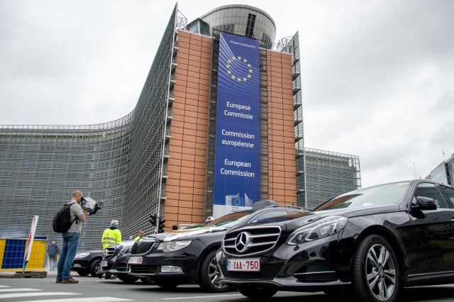16 Sep 2015, Brussels, Belgium --- Bruxelles, Belgium. 16th September 2015 -- A Mercedes luxury taxi with European commission headquarters in the background. -- Hundreds of taxis brought traffic to a standstill today throughout Brussels, Belgium whilst protesting against competition service Uber on Sept 16, 2015. They blockaded the Schuman roundabout outside European Commision. --- Image by © HARRY PROUDLOVE/Demotix/Corbis