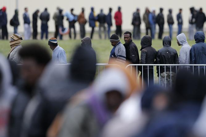 Migrants from Africa, Afghanistan and Syria queue for an evening meal at the Jules Ferry day center in Calais, France, April 29, 2015. African migrants, principally from Eritrea and Sudan,  gather in this northern French port city after they travelled from the Mediterranean northwards in the hopes of crossing the English Channel and seeking asylum in Britain. After up to 900 people drowned trying to reach Europe from Libya last week, EU leaders tripled a naval search mission in the Mediterranean to try to prevent record numbers of people drowning as they try to flee war and poverty in the Middle East and Africa.  REUTERS/Pascal Rossignol   - RTX1AVJD