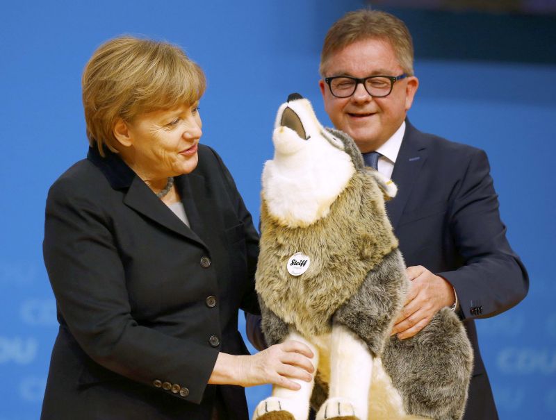 German Chancellor Angela Merkel and leader of the Christian Democratic Union (CDU) receives a gift of a Steiff soft toy dog during the CDU party congress in Karlsruhe, Germany December 14, 2015.   REUTERS/Kai Pfaffenbach