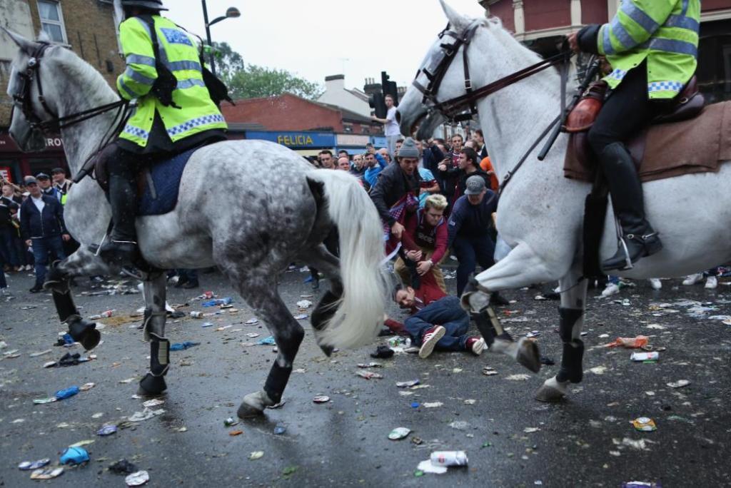 LONDON, ENGLAND - MAY 10: A man is knocked over by police horses as West Ham fans become violent and start throwing bottles at police outside the Boleyn Ground, the Home of West Ham United football club on May 10, 2016 in London, England. Tonights Premier League match against Manchester United is the last game at the Boleyn Ground, bringing to an end 112 years of the clubs history at the ground. The club will move into the Olympic Stadium next season, making way for developers and plans for 800 new homes where the stadium now stands. (Photo by Dan Kitwood/Getty Images)