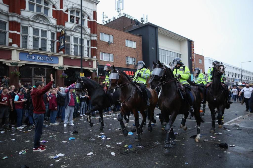 LONDON, ENGLAND - MAY 10: A man stands in the way of police horses as West Ham fans become violent and start throwing bottles at police outside the Boleyn Ground, the Home of West Ham United football club on May 10, 2016 in London, England. Tonights Premier League match against Manchester United is the last game at the Boleyn Ground, bringing to an end 112 years of the clubs history at the ground. The club will move into the Olympic Stadium next season, making way for developers and plans for 800 new homes where the stadium now stands. (Photo by Dan Kitwood/Getty Images)